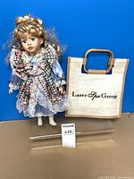 Front view of porcelain doll and jute tote bag