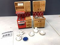 Front view of two wooden kitchen units with stove and sink, porcelain accessories displayed