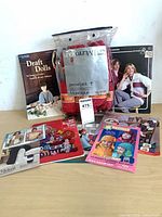 Lot overview with bagged red yarn and assorted pattern booklets displayed