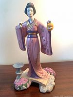 Front view of porcelain figurine with base and lantern
