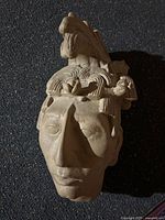 Front view of clay Aztec head sculpture