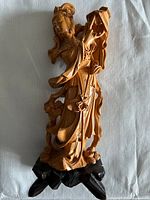 Front view of female carved wood figure on base