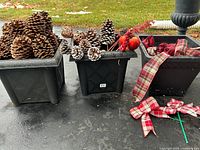 Three plastic planters with pinecones, ornaments, ribbons