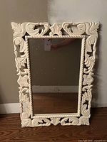Front view of ornate white framed mirror