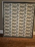 Front view of framed uncut Canadian $1 banknotes sheet
