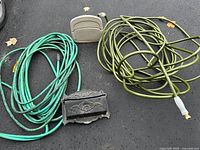 overview of two hoses, hose hanger and mailbox on pavement