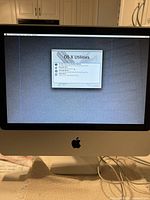 Front view of powered-on iMac showing OS X Utilities screen and vertical pixel line defect