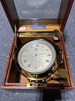 Compass in open wooden box showing dial and gimbal