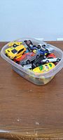 Plastic tub filled with assorted die-cast cars