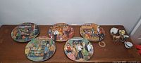 Overview of five decorative plates with Italian market scenes and four small ceramic pieces on right