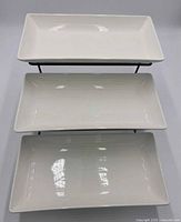 Assembled view showing three white porcelain trays on metal stand