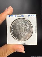 Obverse of 1879-S Morgan dollar in cardboard flip with handwritten details