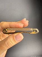 Front view of gold-tone safety pin brooch showing texture and finish