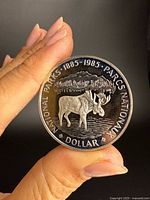 Reverse of 1985 Canadian National Parks Centennial silver dollar showing moose design and dates 1885-1985