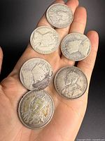 Obverse view of six Canadian silver half dollars in hand