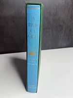 Spine view of blue clothbound book in green slipcase