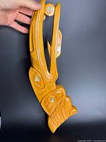 Front view of carved yellow cedar Raven plaque with abalone inlay, showing overall design and finish