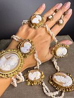 Suite displayed on hand showing necklace segments, bracelet and earrings