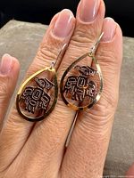 Close-up of both earrings showing gold outline, copper eagle centre and sterling hooks