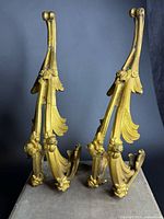 Pair of gilt bronze curtain hooks front view showing ornate leaf and flower design