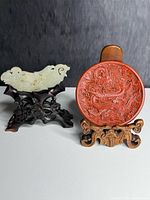 Front view showing jade plaque on stand and red lacquer dragon dish on stand