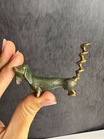 Side view of bronze dachshund bottle opener showing corkscrew tail and Israel mark