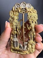 Front view showing figural design and mixed metal finishes