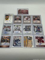 All 13 autographed cards laid out in protective sleeves