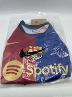 Jersey in sealed bag showing crest, sponsor, color split