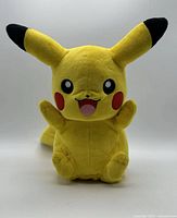 Front view of Pikachu plush showing facial details and pocket
