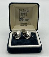 Front view of rose screw-back earrings in box