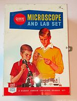 Lid of metal box showing Gilbert Microscope and Lab Set graphics