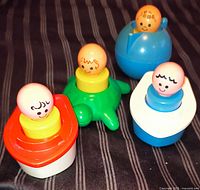 Group shot of four Fisher-Price Jumbo Little People bath toys with figures seated