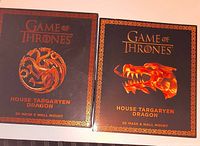 Front view of two boxed Game of Thrones House Targaryen Dragon 3D mask & wall mount kits