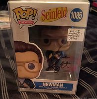 Front view of boxed, autographed Funko Pop in protector