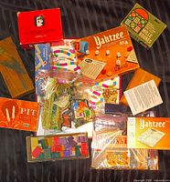 Overview of all boxed games, loose board, figures and pieces spread on surface