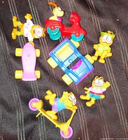 Group shot of all seven Garfield and Odie Happy Meal toys showing vehicles and accessories