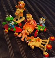 Group of five vintage McDonald's Muppet Babies Happy Meal toys on striped fabric
