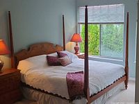 Full view of assembled four-poster bedframe with mattress and bedding