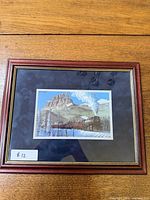 Full view of framed artwork on wood surface