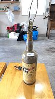Front view of whisky bottle lamp showing label and bulb socket