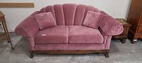 Front view of dusty rose loveseat with two pillows