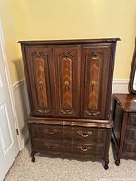 Front view of vintage tallboy dresser showing cabinet doors and drawers