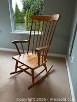 Full view of wooden spindle-back rocking chair showing seat, back, armrests and rockers