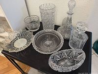 Group shot of all cut-glass pieces on black surface