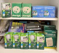 Shelf view showing Greenlite LEDs, plant-light boxes, Westinghouse spot bulbs and surge protector