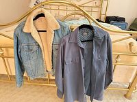Front view of sherpa denim jacket and blue work shirt hanging
