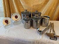 Stainless steel and glass canisters alongside utensils