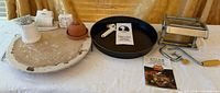 All items arranged: pasta maker, pizza pan, pizza stone, small accessories