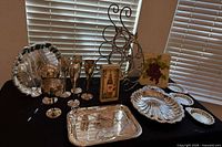 overview of lot with trays, shell dishes, stemware, wine rack, wall décor box, trivet